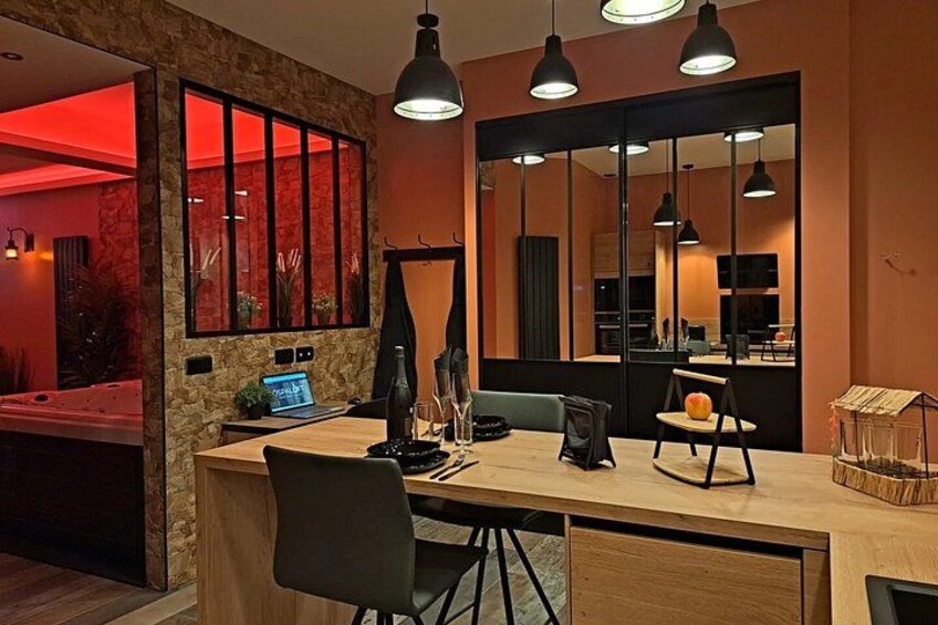 A modern dining area with a wooden table, black chairs, and pendant lighting. 5