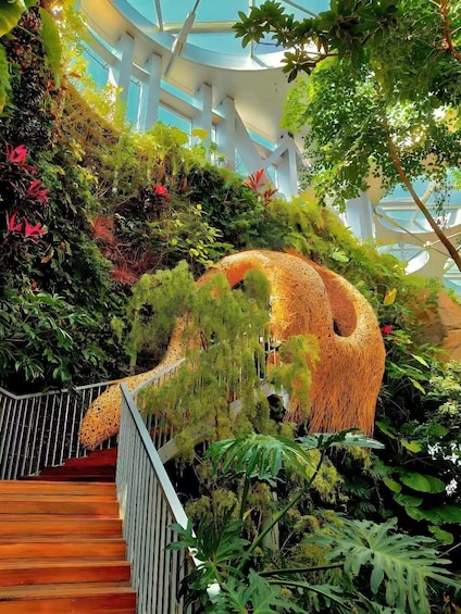 A staircase surrounded by lush greenery and a large, spherical structure made of natural materials. 1