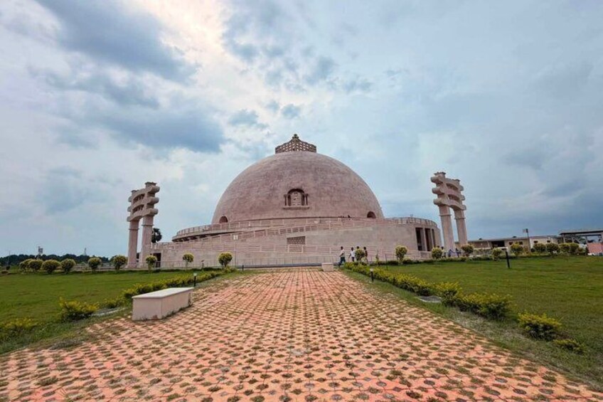 A large domed building with a paved pathway leading to it. 2