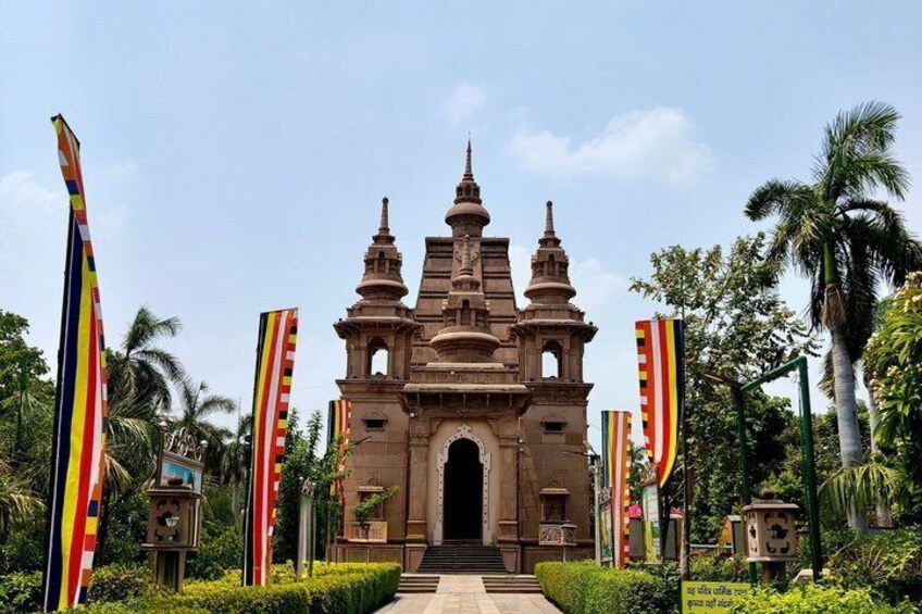 A colonial-style building with a central dome and two towers, surrounded by lush greenery and palm trees. 3
