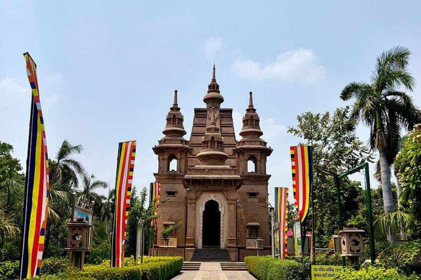A colonial-style church with a central dome and two bell towers, surrounded by lush greenery and palm trees. 3