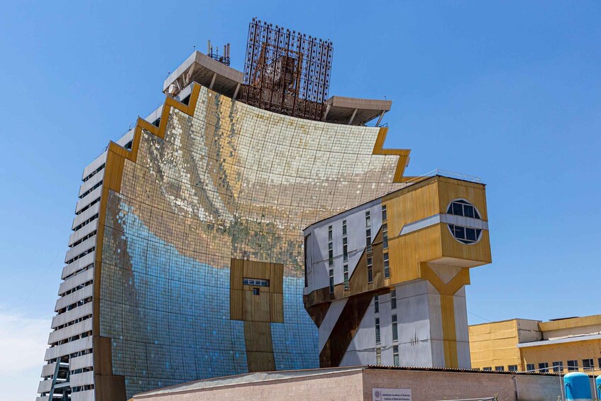 A modern architectural building with a unique design, featuring a large reflective surface and a mix of geometric shapes. 1