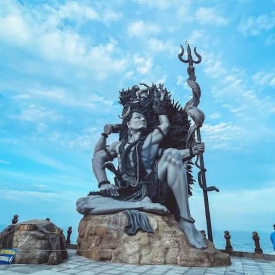 A statue of a mythological figure seated on a rock with a trident. 2