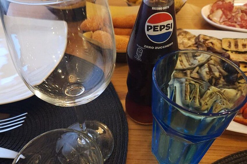Et bord med et glas vand, en Pepsi-flaske og et blåt glas med isterninger. 5