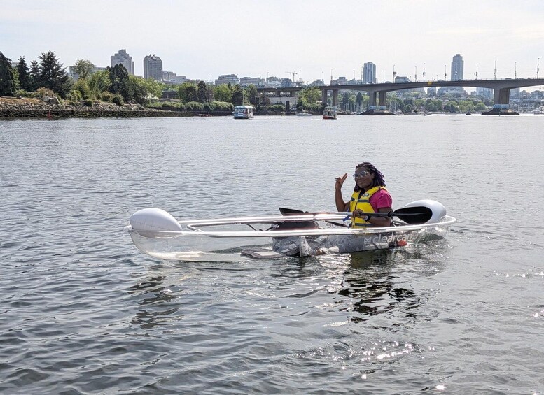 A person in a kayak on a river with a bridge in the background. 3