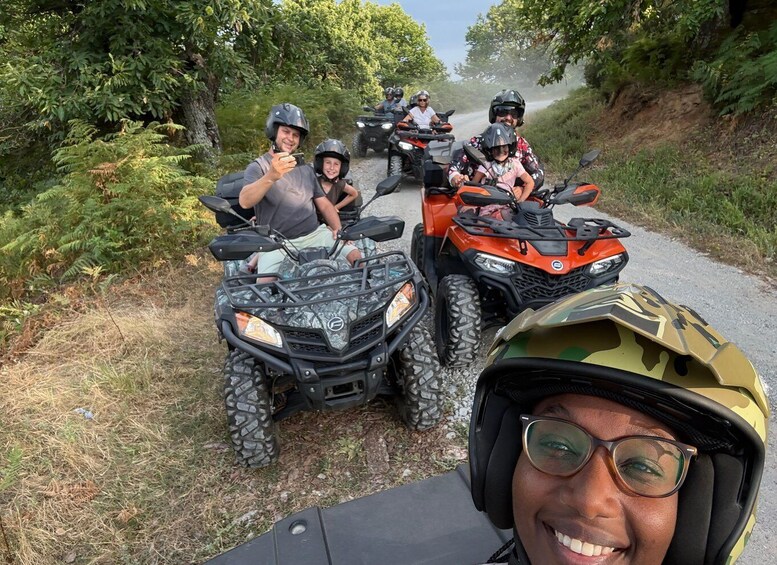 A group of people on ATVs on a dirt road surrounded by greenery. 5