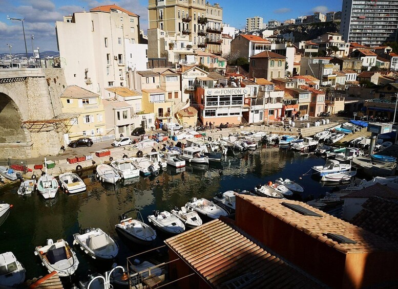 A coastal town with a marina filled with boats, historic buildings, and a stone bridge. 5