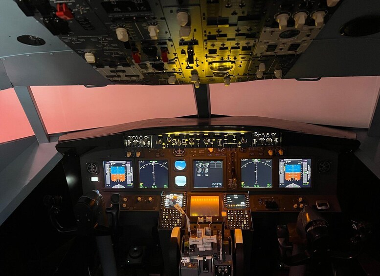 An aircraft cockpit with multiple instrument panels, control switches, and illuminated displays. 4