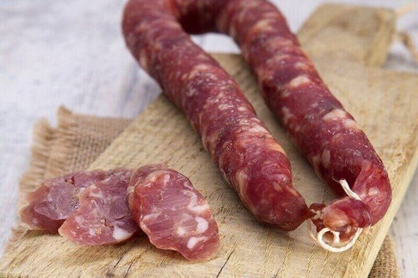 Two sausages on a wooden cutting board. 1
