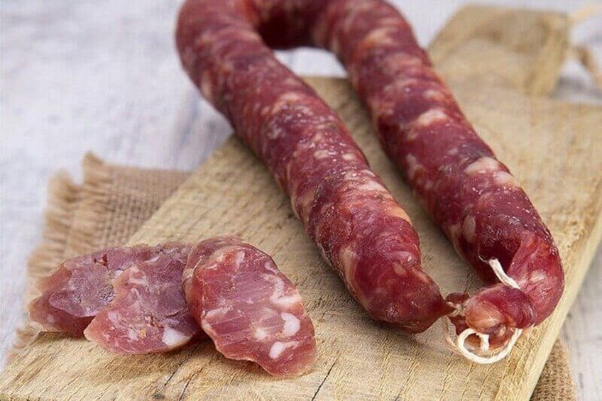 Two sausages on a wooden cutting board. 1