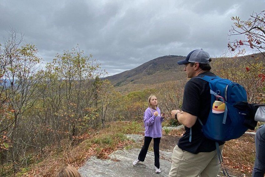 A man and a woman hiking in a mountainous area with autumn foliage. 2