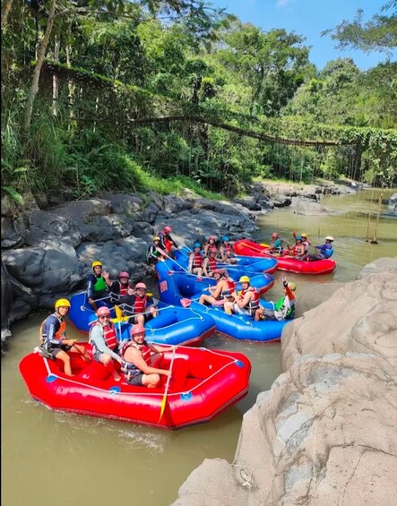 People rafting on a river surrounded by rocks and greenery. 4