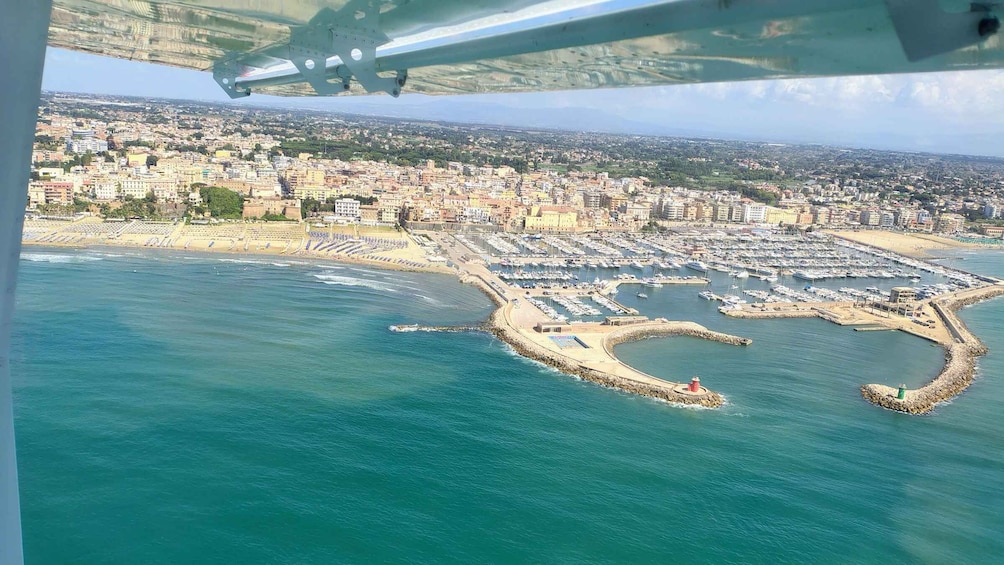 An aerial view of a coastal city with a marina, beach, and urban area. 2