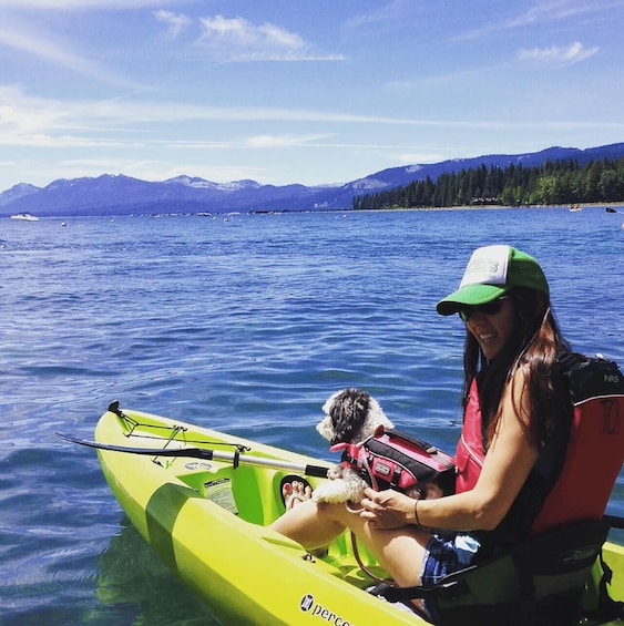A person in a kayak on a lake with mountains in the background. 2