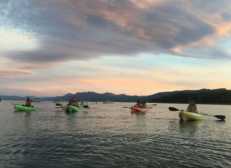 People kayaking on a lake with mountains in the background. 1