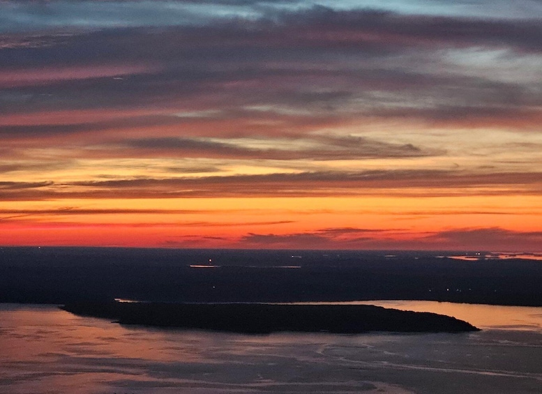 A sunset over a body of water with a distant landmass. 2