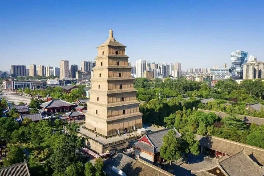 A traditional pagoda surrounded by modern buildings and greenery. 1