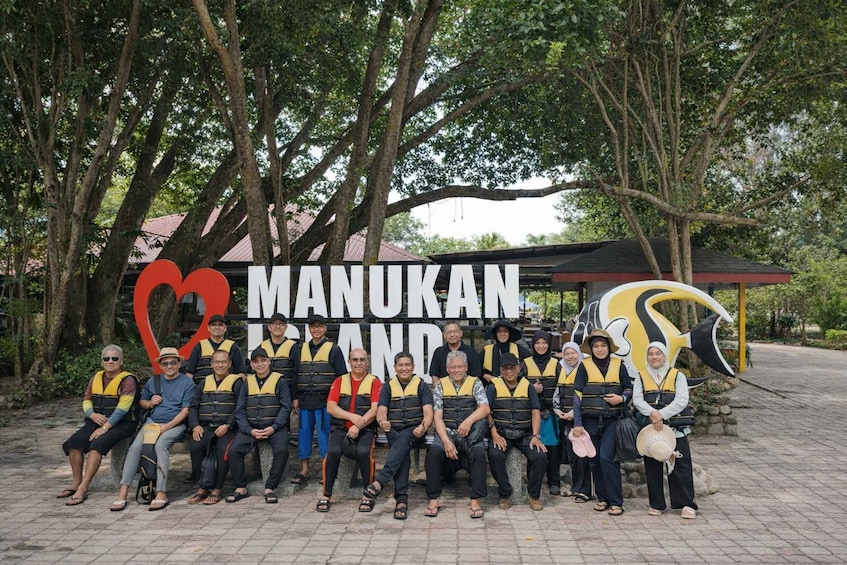 A group of people posing in front of a sign with the text 'MANUKAN BRAND.' 3