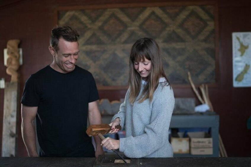A man and a woman in a workshop setting, engaged in a woodworking activity. 2
