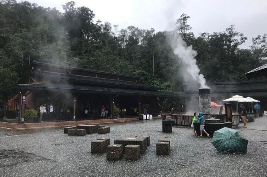 A traditional Japanese building with a steam vent, surrounded by a gravel area with stone benches. 3