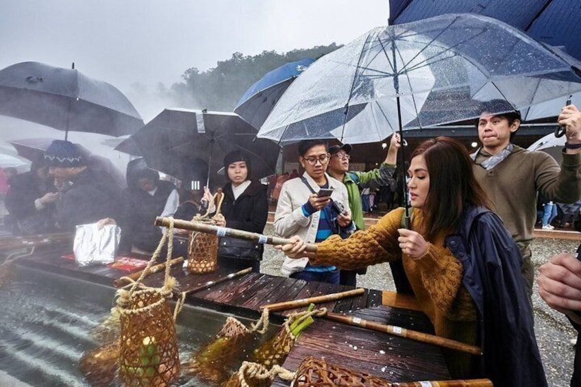 A traditional boat with passengers holding umbrellas, indicating rainy weather. 2