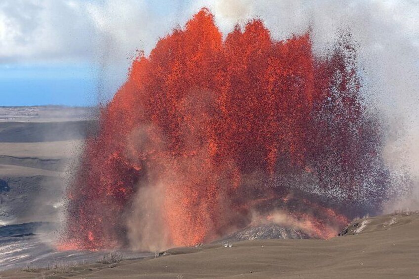 A volcanic eruption with red lava flowing and ash clouds. 1