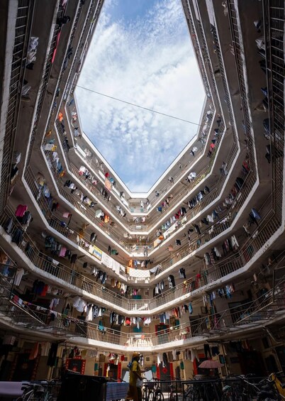 Un edificio de varios niveles con balcones, algunos con ropa tendida. 5