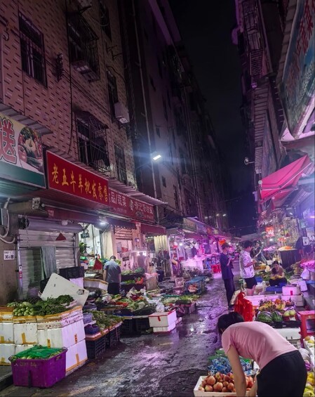 Mercado nocturno con puestos que venden verduras y frutas. 4