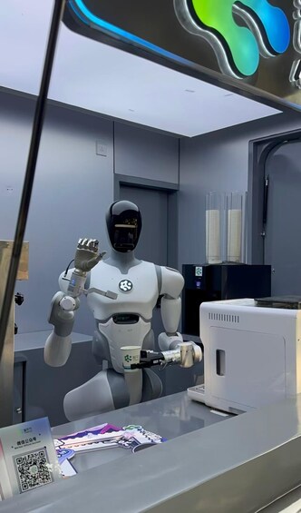Un robot humanoide en una habitación con un monitor de computadora, un código QR y una puerta. 3