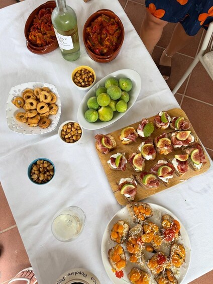 A table with various food items including bruschetta, olives, and a bottle of wine. 3