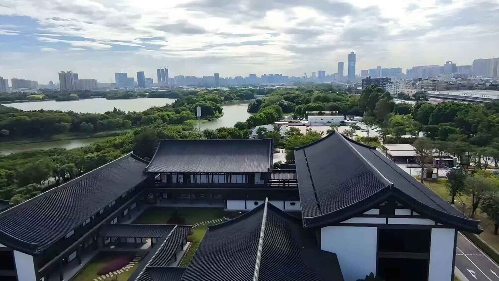 A traditional building with a river and modern cityscape in the background. 2