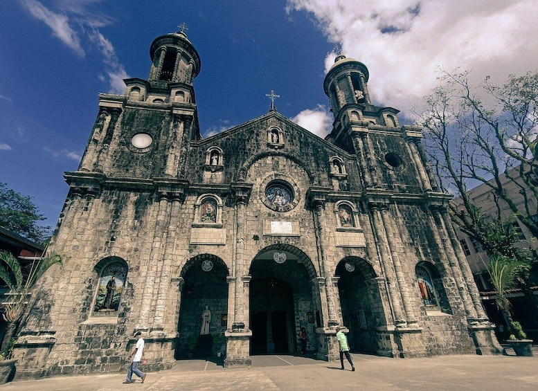 A historic church with two bell towers, arched doorways, and statues. 2