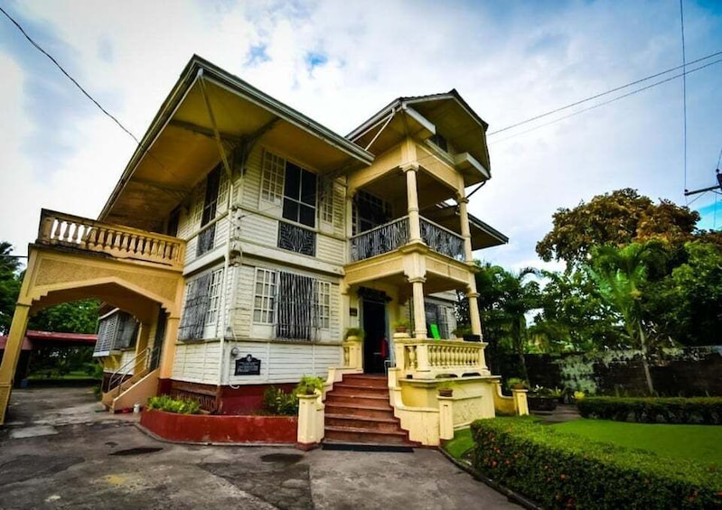 A two-story house with a balcony, a porch, and a staircase leading to the entrance. 3