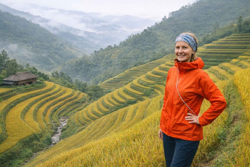 A person standing on terraced rice fields with a mountainous landscape in the background. 1