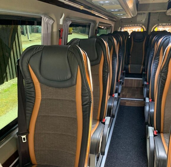 A train interior with rows of seats, windows, and overhead compartments. 2