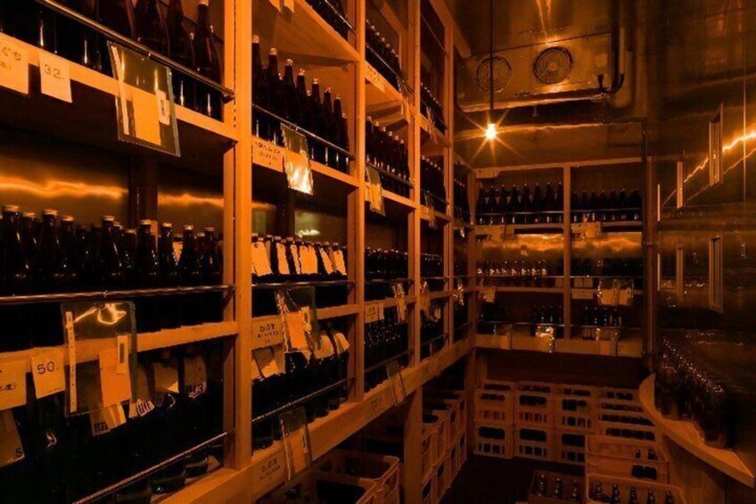 A wine cellar with shelves of bottles and crates. 4