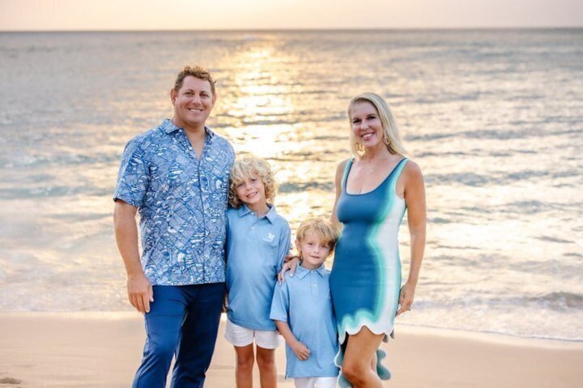 A family of four on a beach with the ocean in the background. 1
