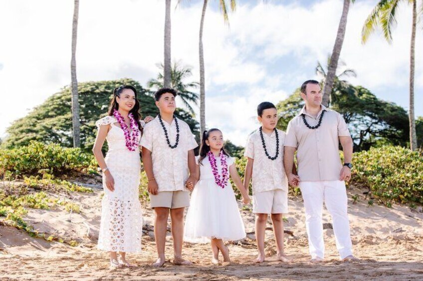 A family on a sandy beach with palm trees in the background. 3