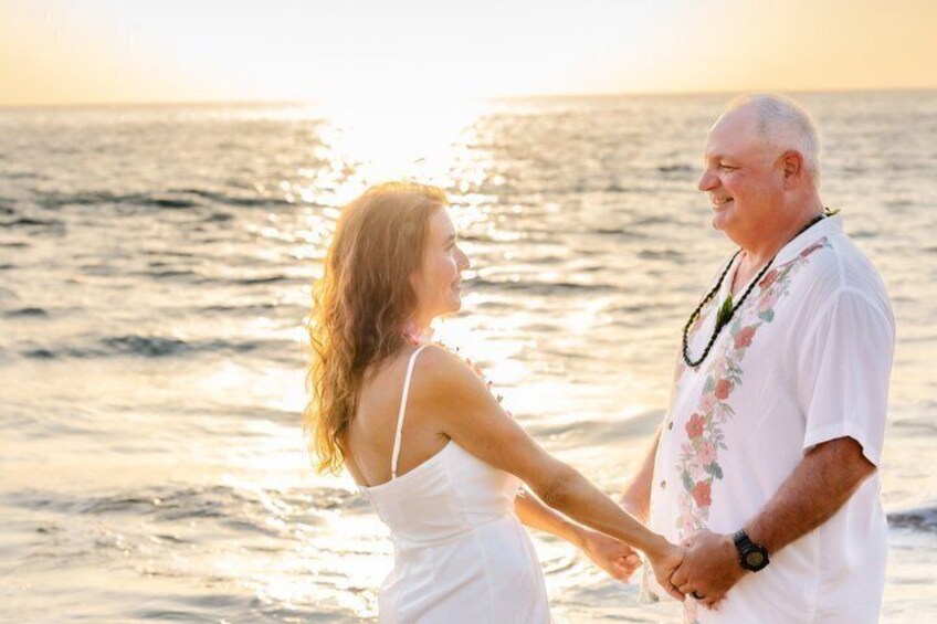 A couple holding hands on a beach at sunset. 5