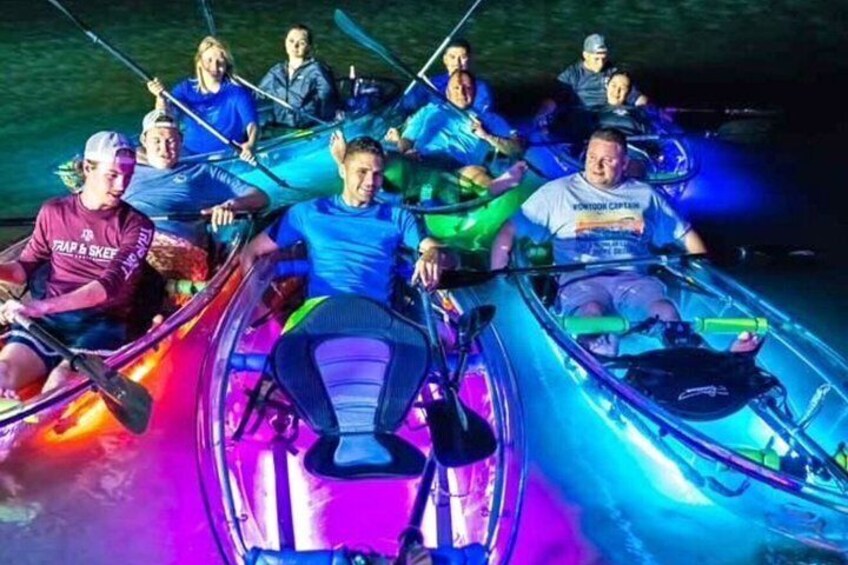 People in canoes on a body of water at night. 5