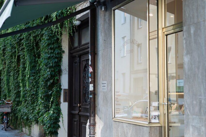 A building with a dark wooden door, a window with a reflection, and a green awning. 2