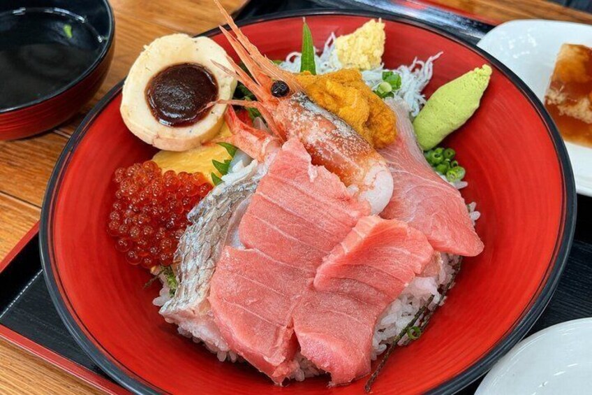 A plate of sushi with various toppings including fish, roe, and wasabi. 4