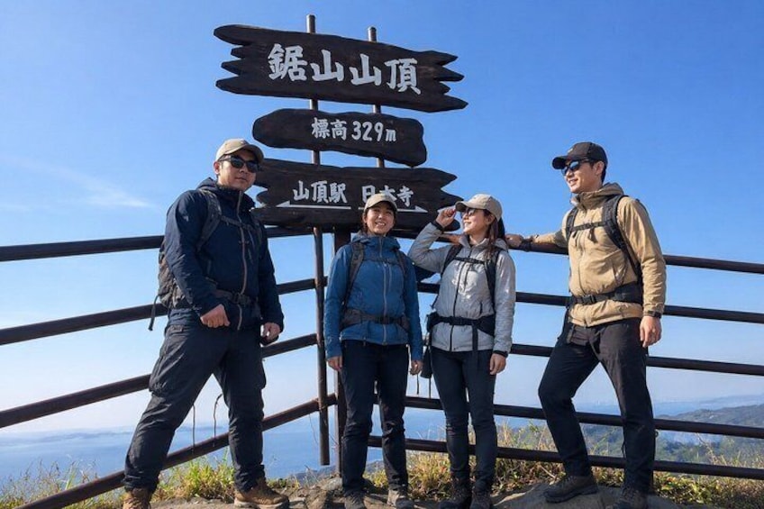Four people standing in front of a signpost with multiple directional arrows and text. 1