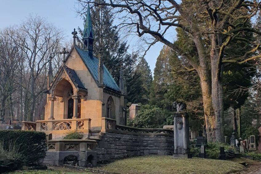 A small church with a green roof, surrounded by trees and a stone wall. 4