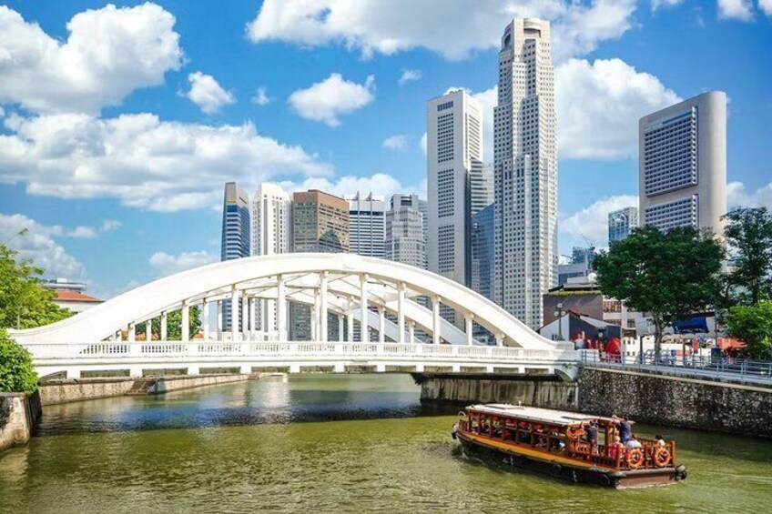 A white bridge over water, a boat with passengers, and a city skyline with tall buildings. 1