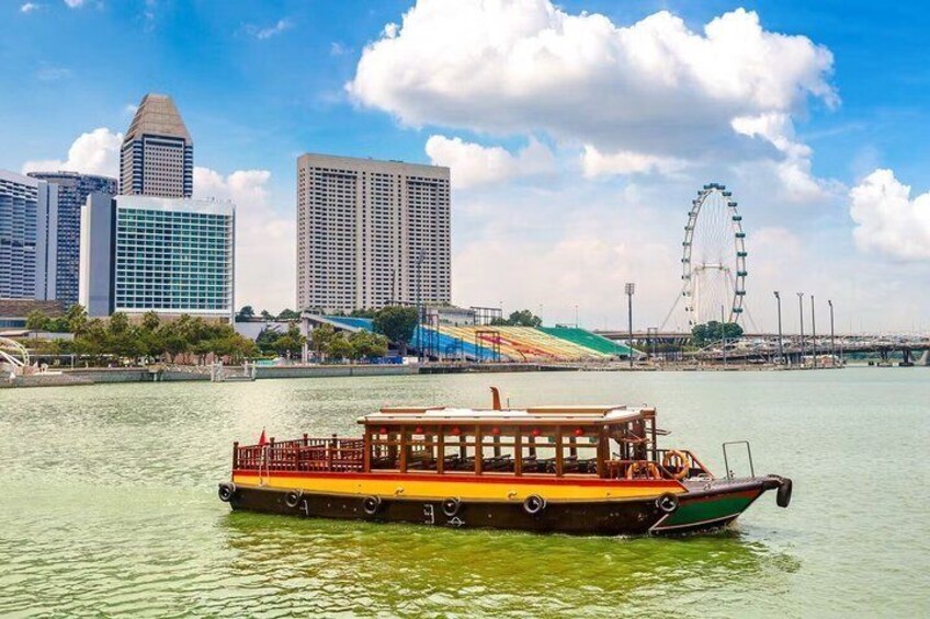 A boat on water with a city skyline and a Ferris wheel in the background. 2
