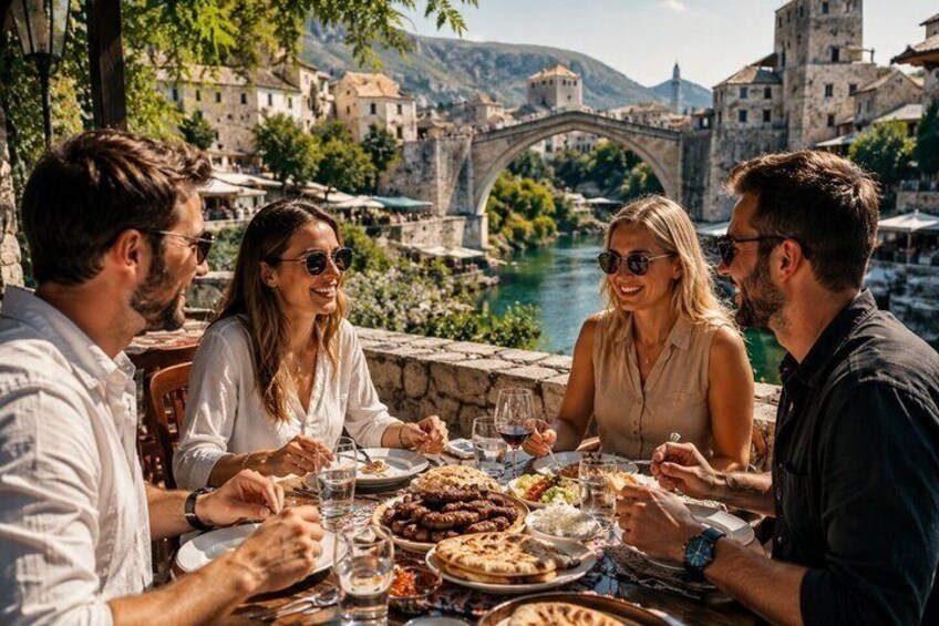 A group of people dining outdoors with a river and historic buildings in the background. 1