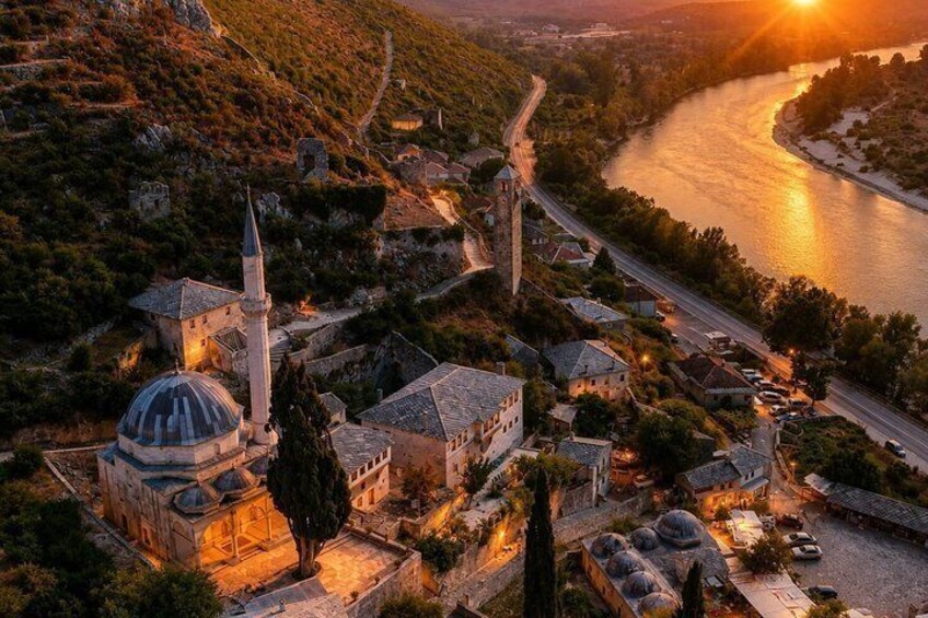 A town with a river, a mosque with a dome, and a tall minaret. 4
