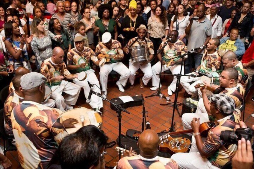 A group of musicians performing in a circle with an audience. 1