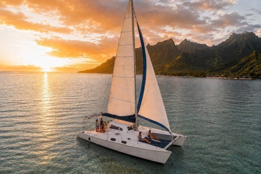 A sailboat on calm waters with a mountainous backdrop during sunset. 1